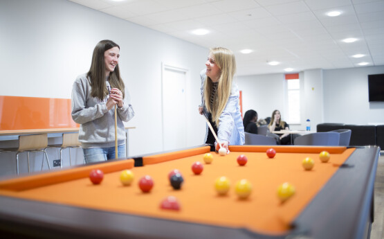 Students playing pool in the communal area in student accommodation