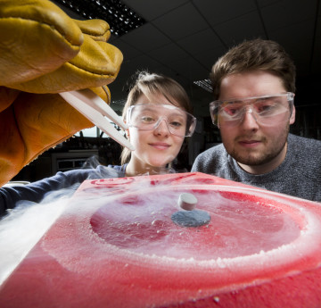 Male and female student conducting an experiment.