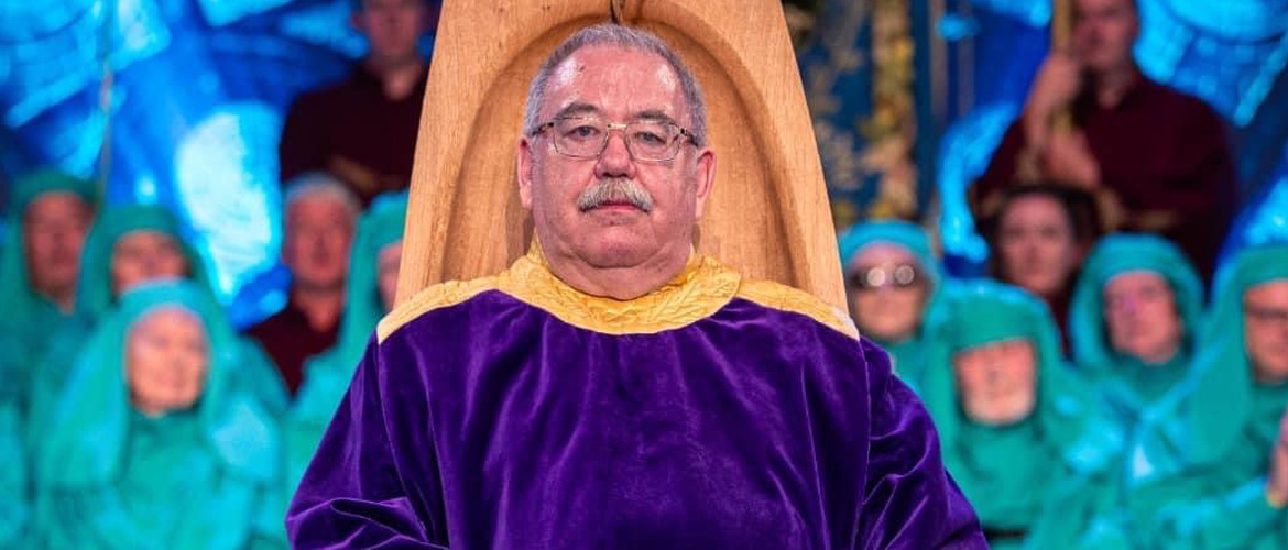 Alan Llwyd in his chair on the stage of the National Eisteddfod 2023