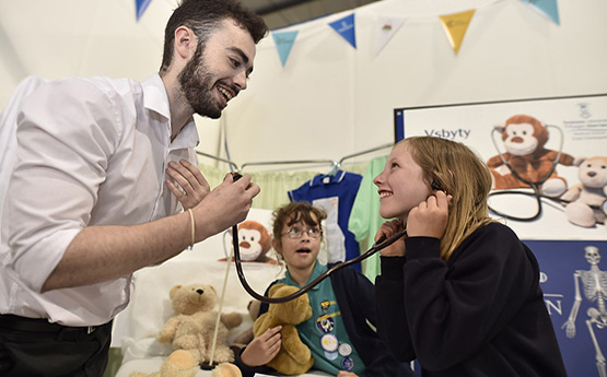 Lecturer and child in the teddy hospital in the GwyddonLe