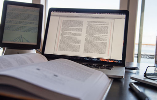 A open textbook in front of a computer