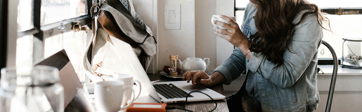 A person writing a blog in a coffee shop