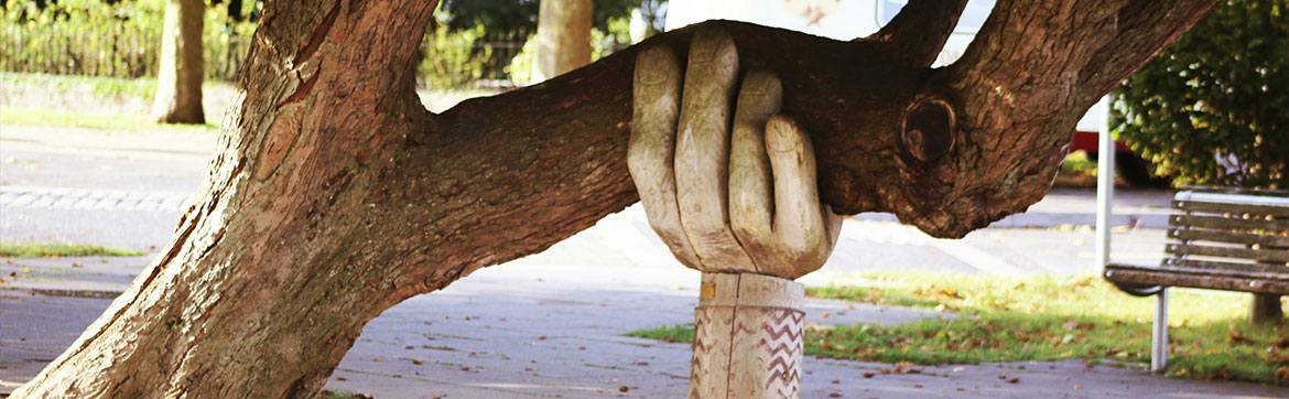 A hand sculpture supporting a tree branch