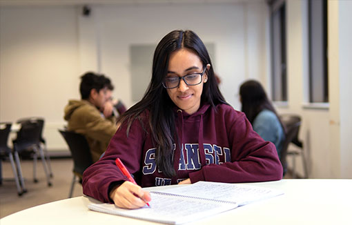 A female student writing on a table