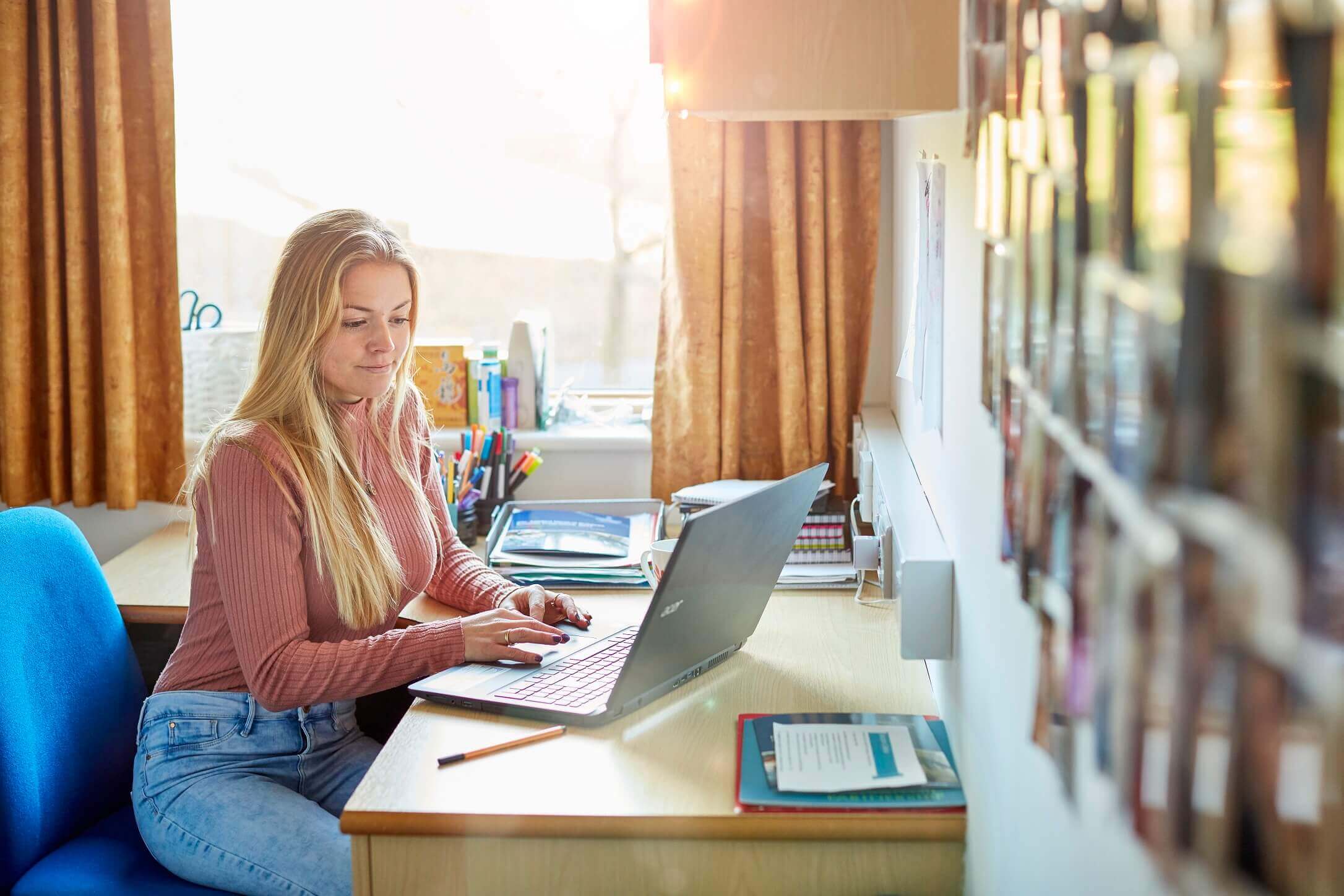 Student sat at laptop in a student halls room