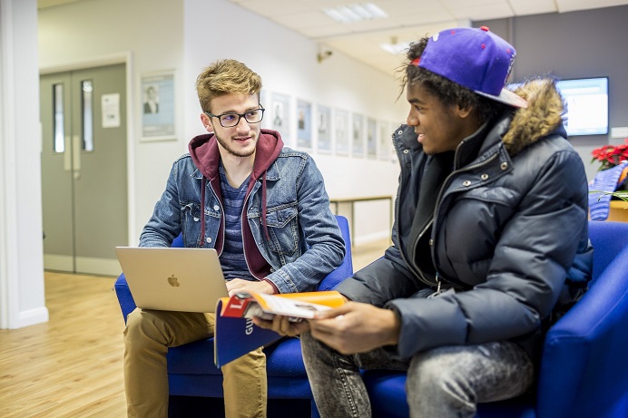 Two students sitting around a laptop