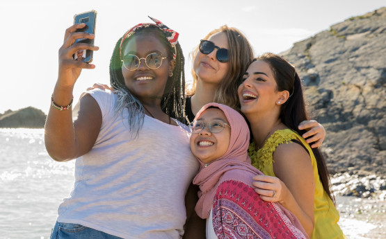 Four students taking a photo o the beach