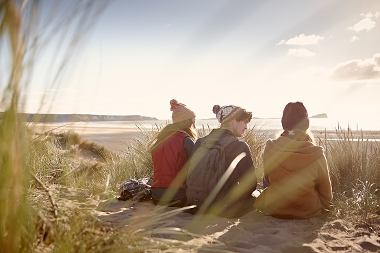 Three students on a beach.