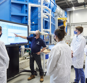 Technician in Wind Tunnel demonstrating to students