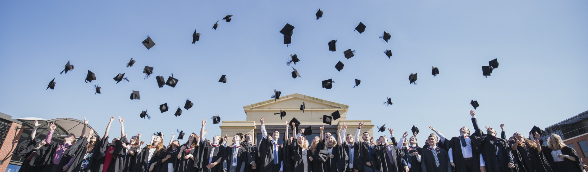 Students at Graduation, throwing their caps in the air