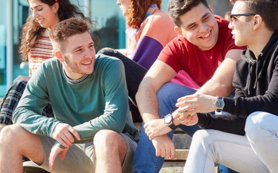 Students sit on the Fulton House steps.