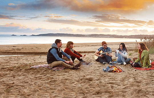 Students sitting on the beach.