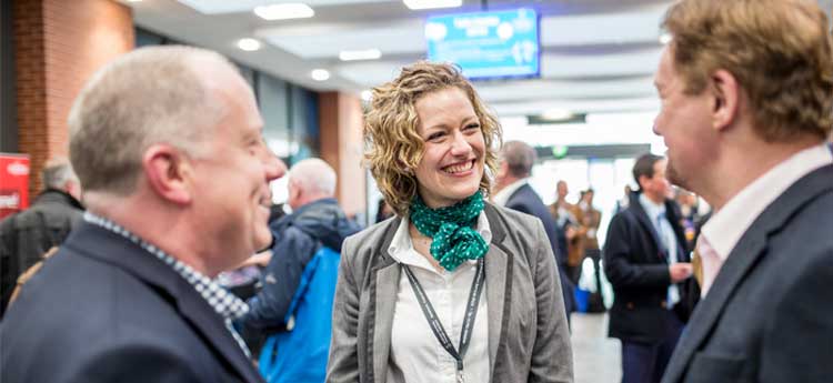 Smart women talking to two men at a networking event