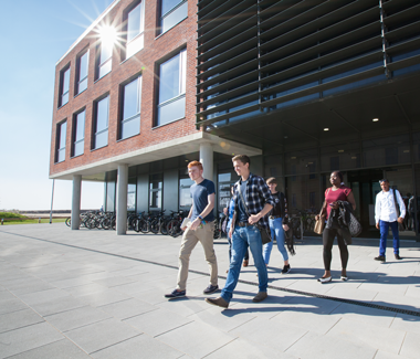 students walking out the entrance of the School of Management