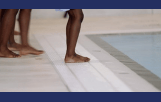 Black swimmer about to jump into pool