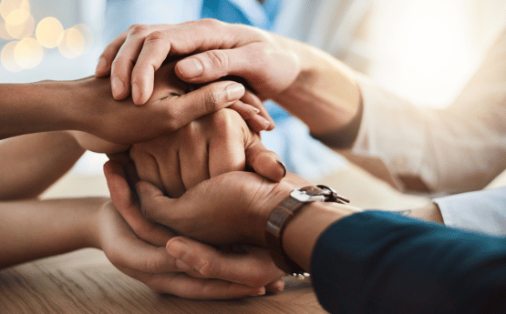 Supportive hands holding a fist.