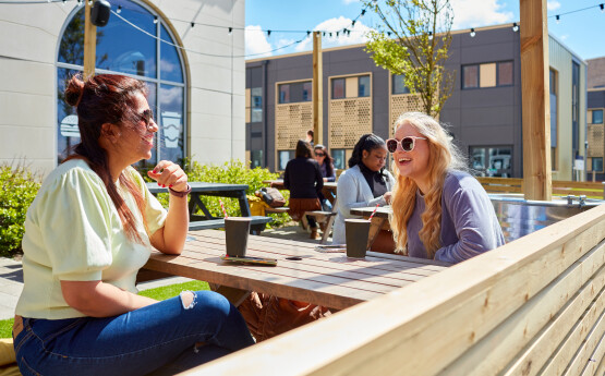 students sat outside drinking a coffee