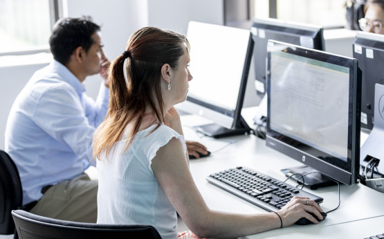 Image of two PGR students using a computer for research