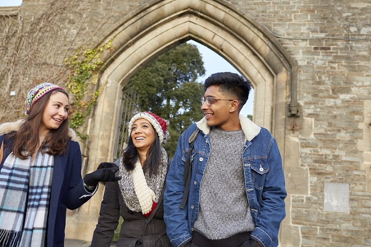 Three students walking through Arch in Singleton Park