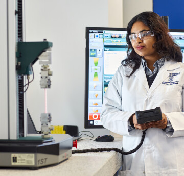 Biomedical Student in the lab with a tensile testing machine