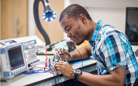 A man placing some wires onto a circuit board