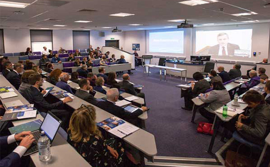 People sitting in a lecture theatre watching a presentation