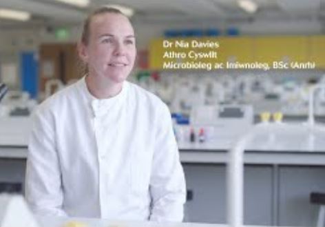 Academic sitting on a stool in a laboratory 