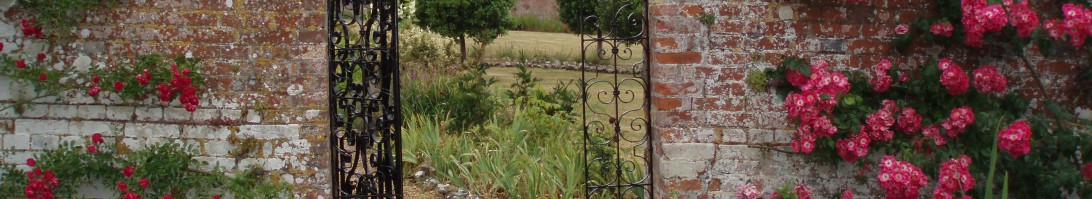 Garden gate surrounded by flowers. 