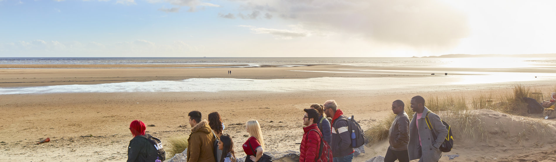 students walking on Swansea beach