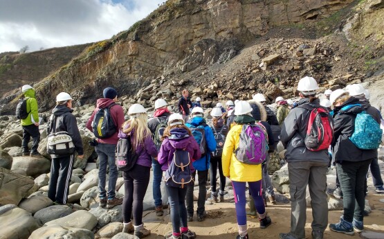 Geography students on a trip looking at rocks