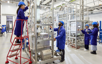 Two student in Pilot Line Lab looking at equipment