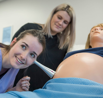 Midwife listening to a baby bump