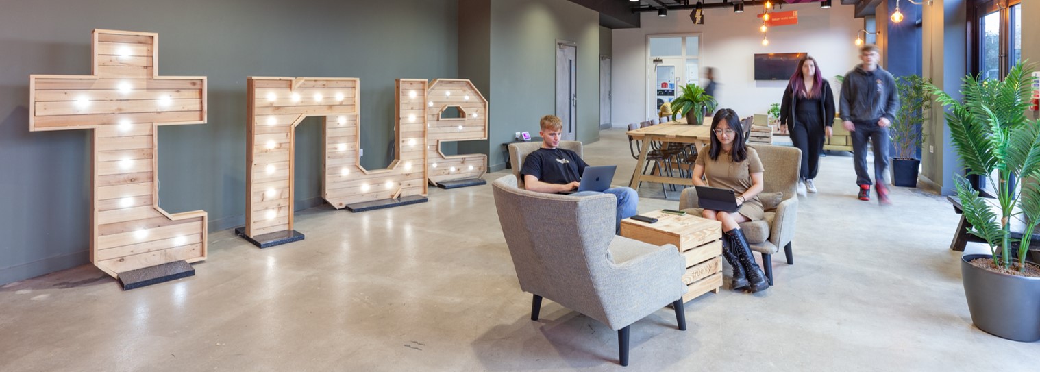 True sign, with students sitting in reception area