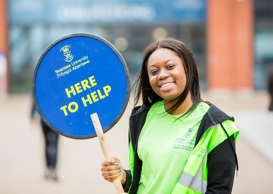 student holding lolipop sign for open day