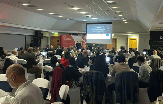 photograph from back of the event room showing guests sat at their tables