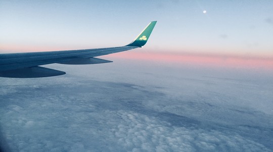 Aeroplan wing in flight as the sun sets.