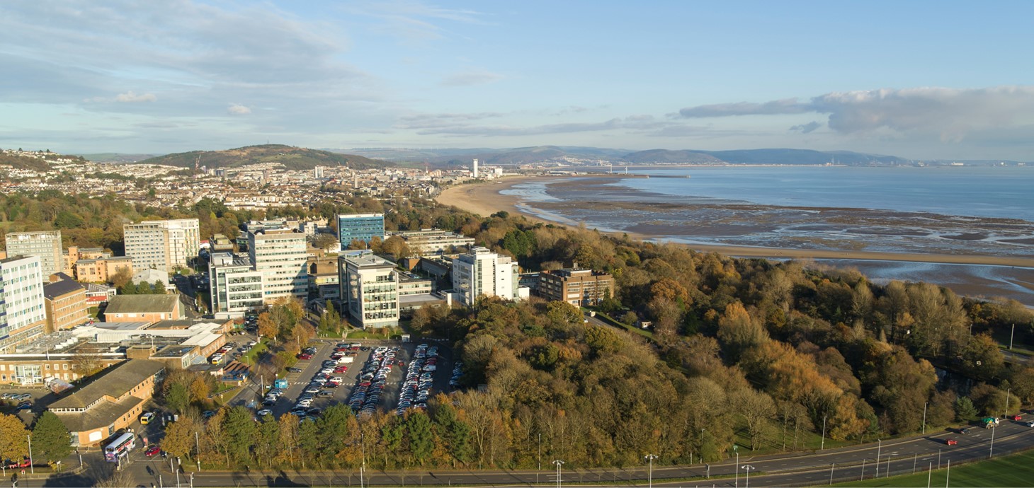 Golygfa o'r awyr o ddinas a bae Abertawe gyda Phrifysgol Abertawe yn y blaendir