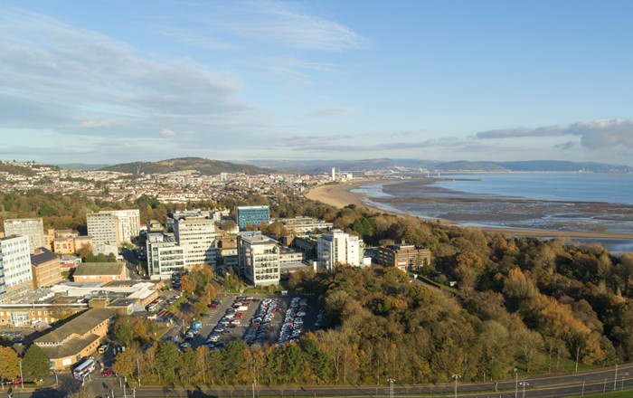 Golygfa o'r awyr o ddinas a bae Abertawe gyda Phrifysgol Abertawe yn y blaendir