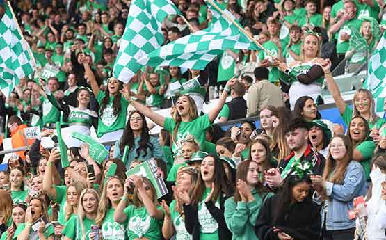 Students at the Liberty Stadium waving Sport Swansea flags during Varsity. 