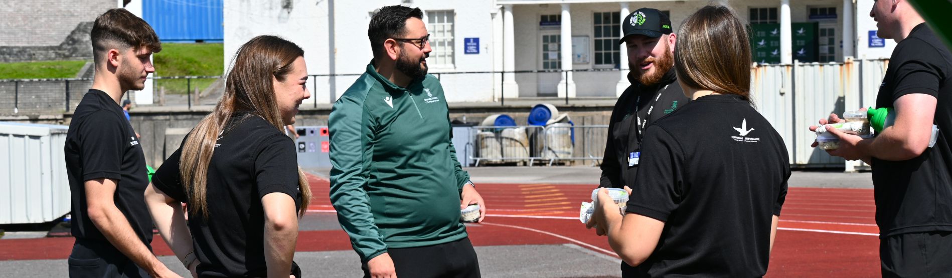 Swansea University High Performance Football Manager John Beale chatting to staff and students at Swansea Bay Sports Park