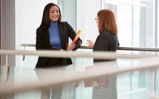 two females standing on a balcony talking