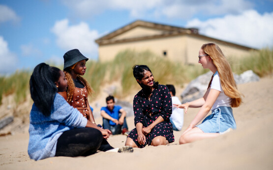 students sitting on the beach