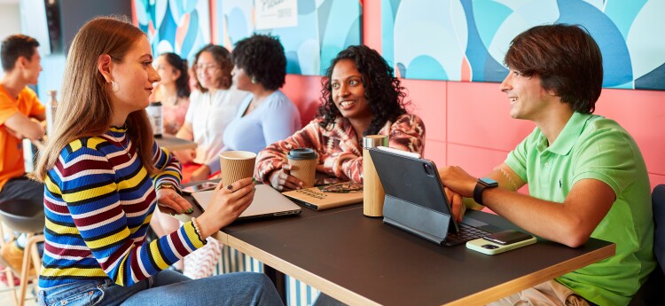 Students sitting at a table with a laptop