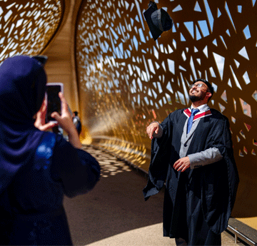 graduates on a bridge