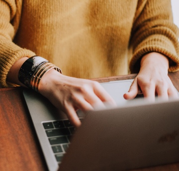 Image of woman typing on a laptop computer keyboard