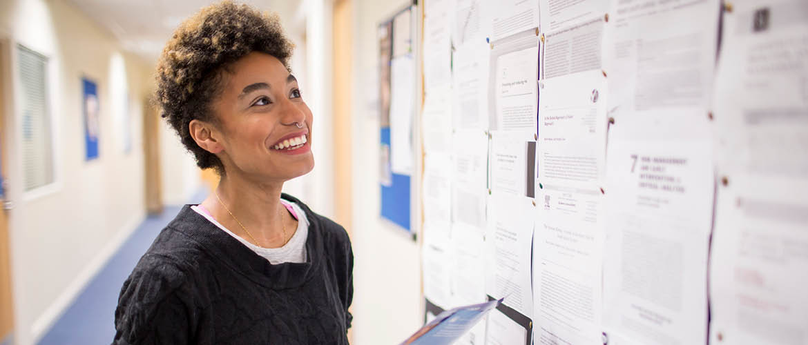 student looking at notes on a wall