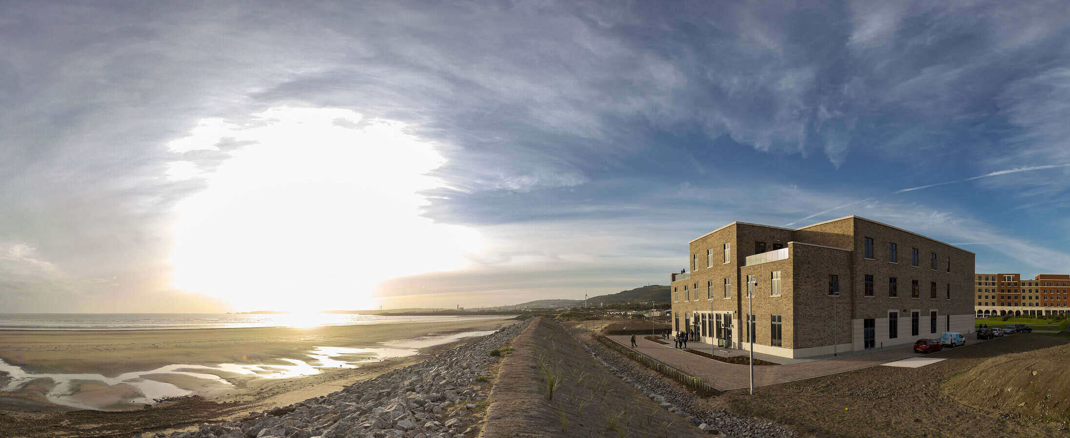 Image of the beach and The College building at Swansea Bay Campus