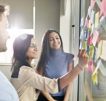 Students working together to put notes on a board