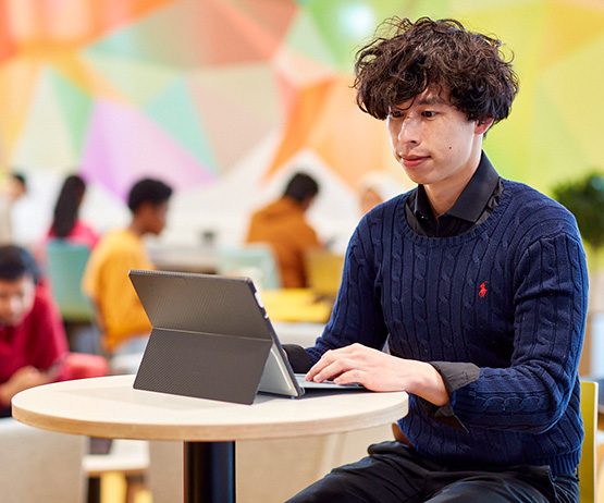 student working on a computer smiling