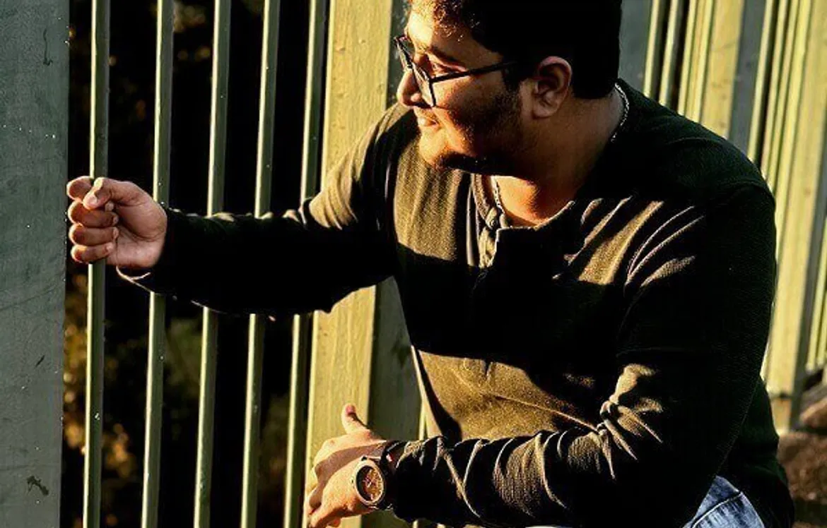 Sriram looking through a fence. 